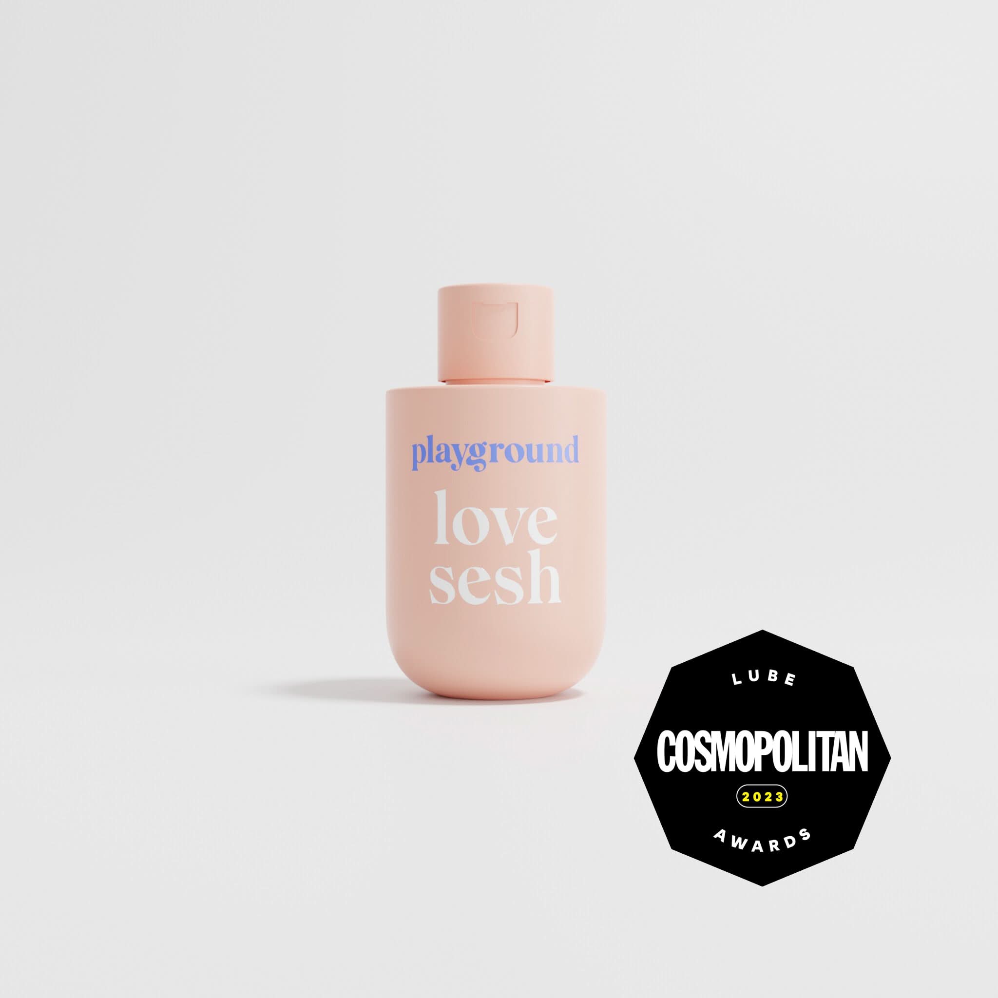 Pink bottle labeled 'playground love sesh' with Cosmopolitan 2023 Lube Awards logo on a light gray background